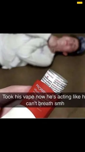 a hand holding an inhaler in the foreground with someone apparently struggling to breath in the background, the caption says "took his vape now he's acting like he can't breath smh"