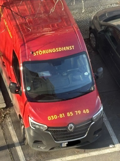 Auto in rot mit der Aufschrift als Werbung „Störungsfienst“ und dann eine telefonnummer