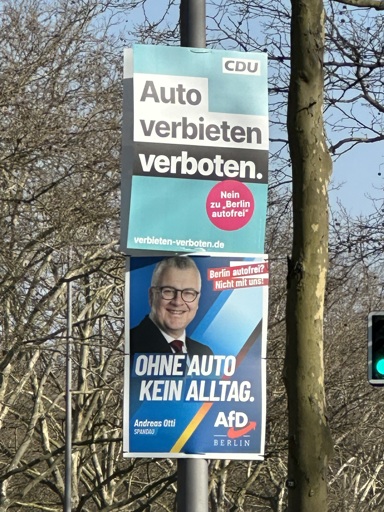 Zwei direkt übereinander aufgehängte Wahlplakate am Laternenpfahl; oben CDU: "Auto verbieten verboten.", untern  AfD: "Ohne Auto kein Alltag."