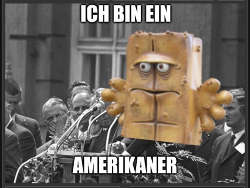 Bild von John F. Kennedy bei seiner bekannten "Ich bin ein Berliner"-Rede. Auf ihn wurde bermd das Brot gepappt, mit dem Text "Ich bin ein Amerikaner"